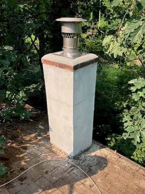 Chimney with a light-colored exterior coating and metal cap.