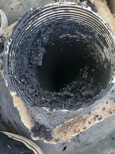 Dark buildup visible inside a metal chimney liner.